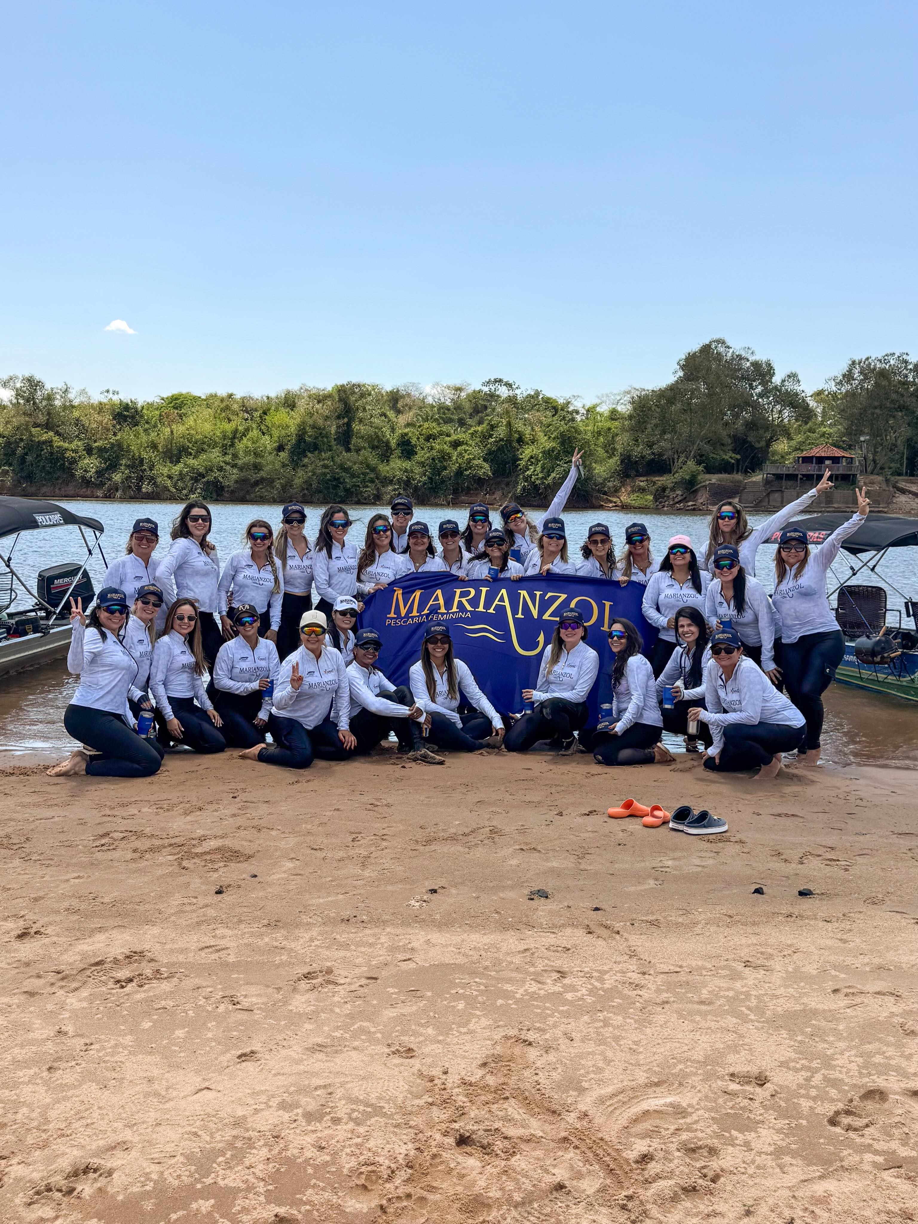 Grupo de mulheres reunidas em uma expedição da Marianzol à beira do rio